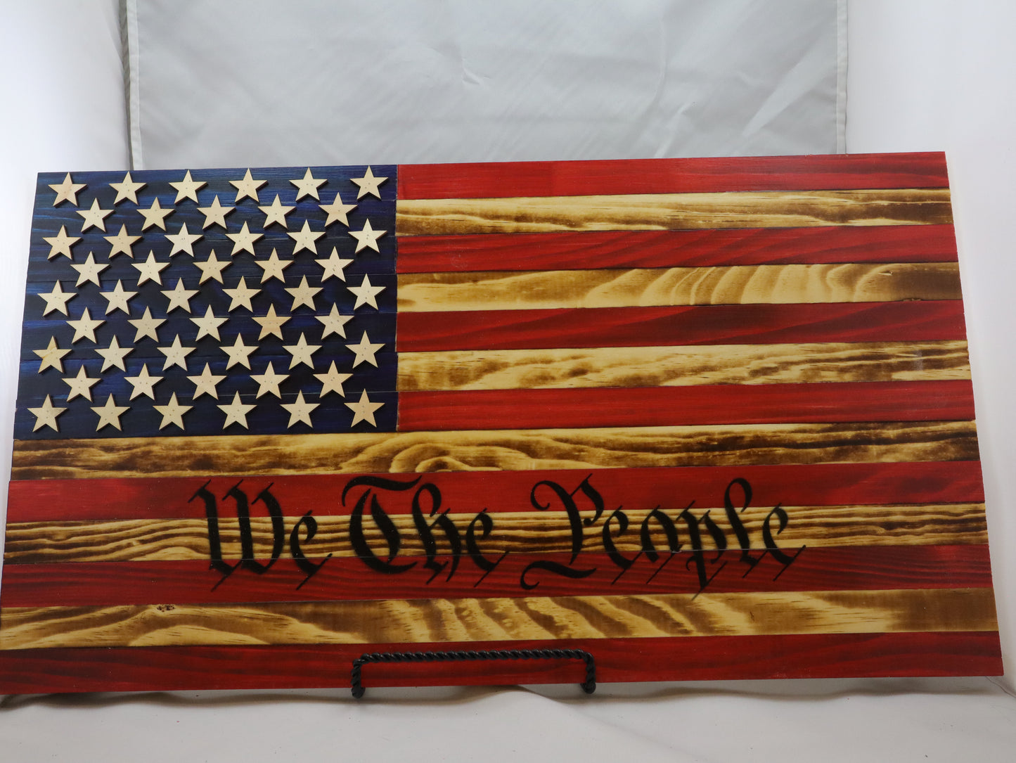 We the People Wooden Flag Wall Art featuring an American flag design with carved stars and scripted text