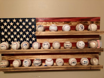 American flag baseball rack display holding multiple signed baseballs on wooden shelves