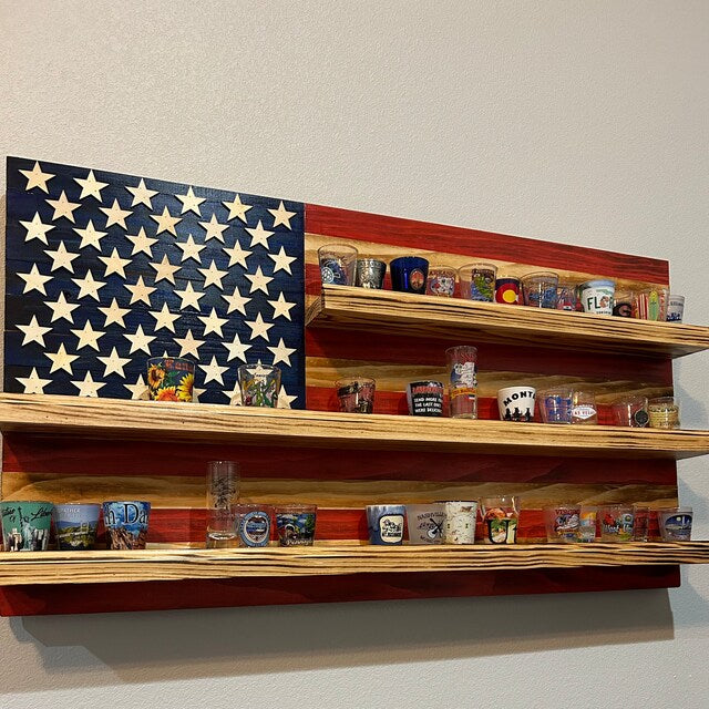 American flag shot glass holder display wall art made of wood with three shelves holding various shot glasses