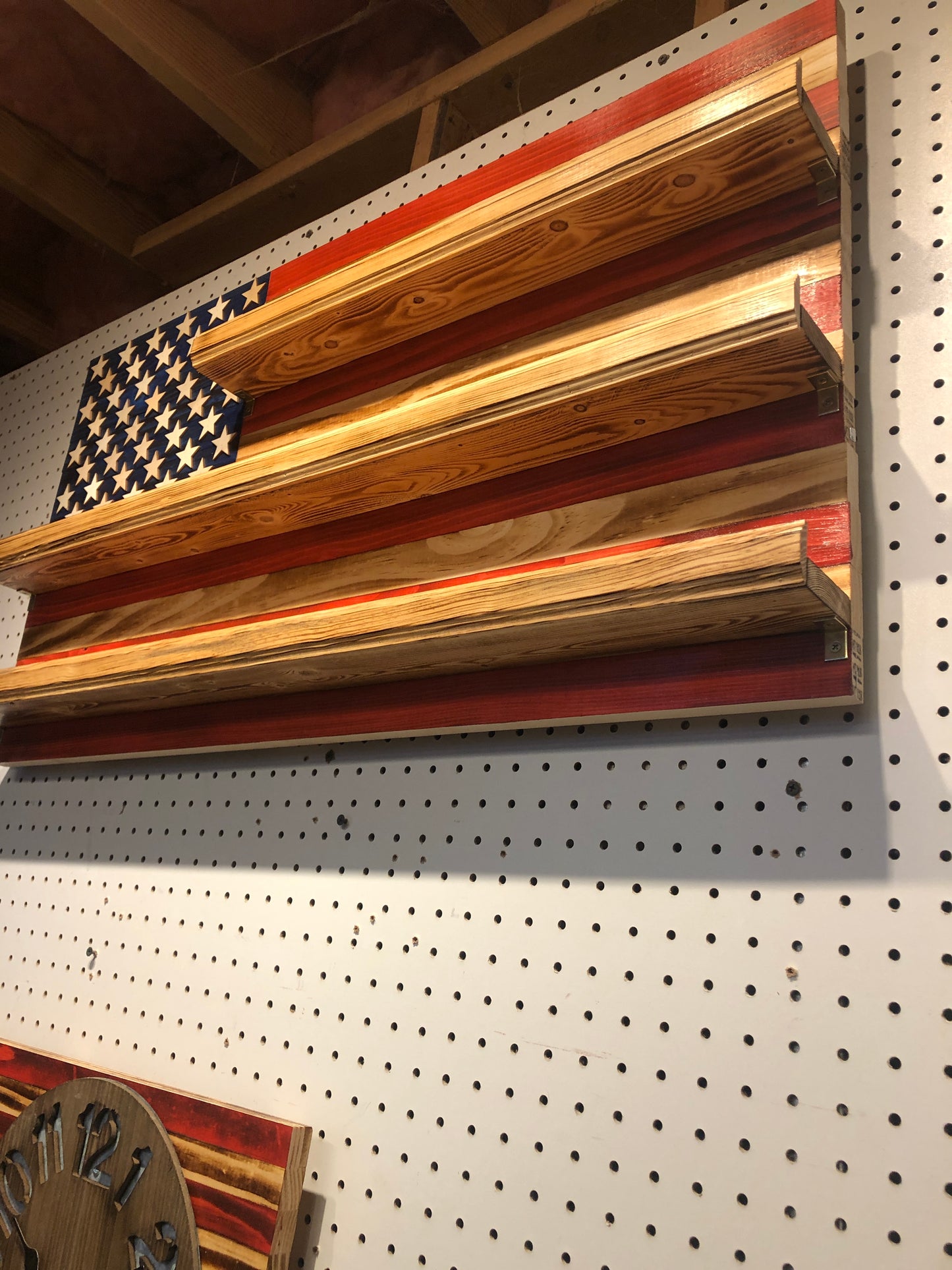American flag shot glass holder display wall art made of wood with rustic finish mounted on a pegboard wall