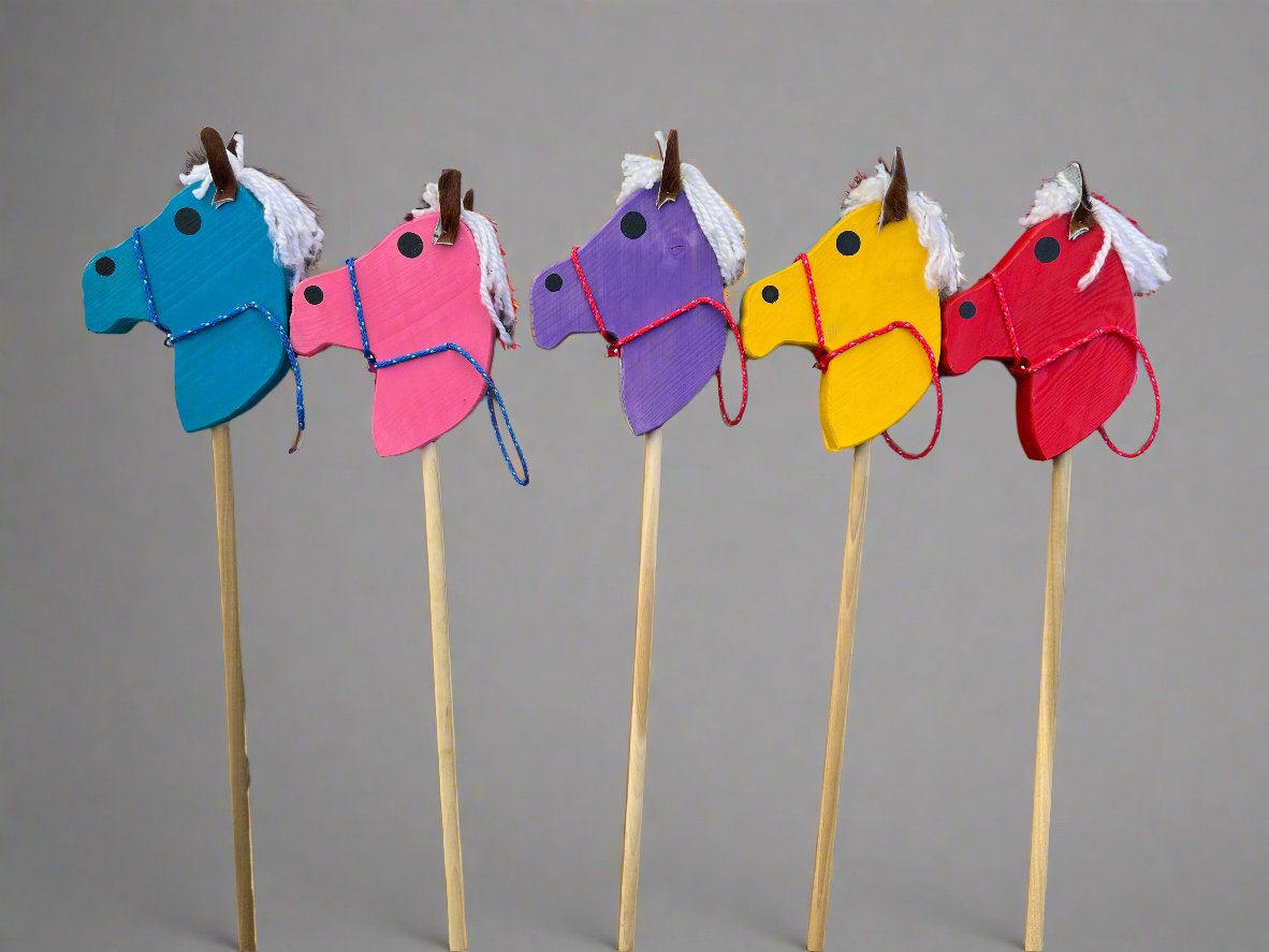 Colorful kids wooden hobby horses in blue, pink, purple, yellow, and red with white manes on sticks