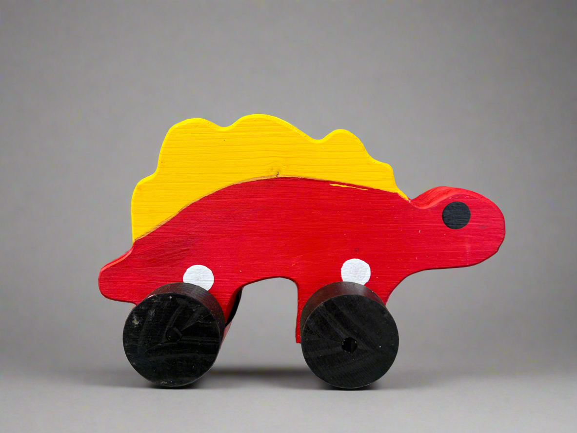 Handcrafted dinosaur kids pull toy in red and yellow wood with black wheels for toddlers