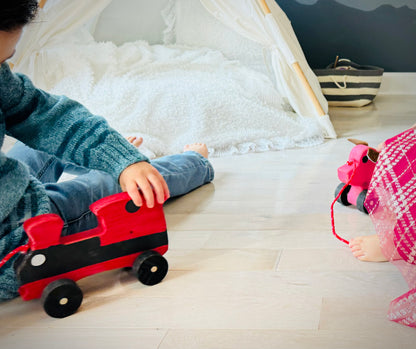 Child playing with a handcrafted wooden train kids pull toy in a cozy room with light wood flooring