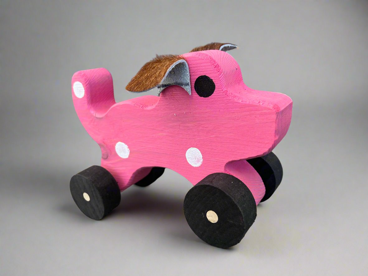 Handmade wooden dog pull kids toy in pink with black wheels and white spots