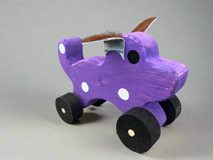 Purple handmade wooden dog pull kids toy with black wheels and white spots