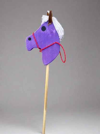 Purple kids wooden hobby horses with white yarn mane and red bridle on wooden stick