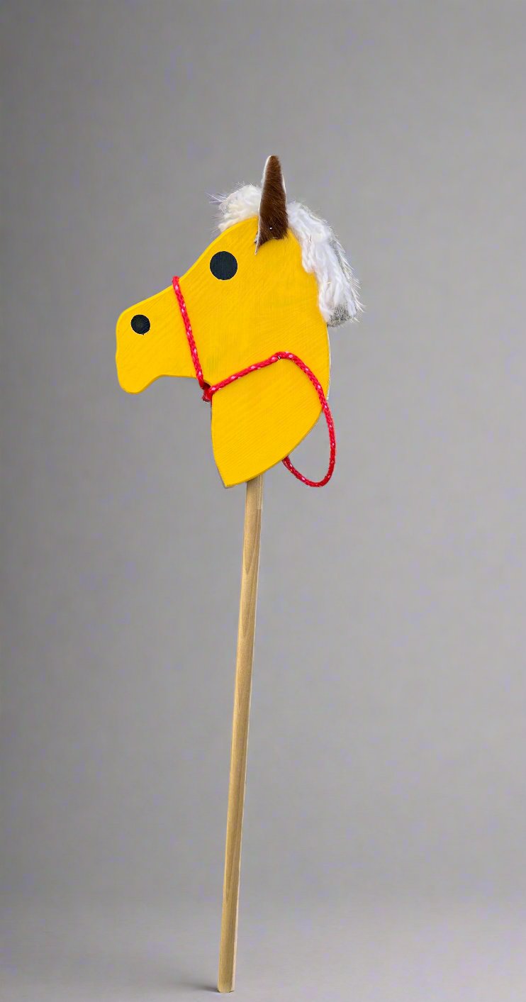 Yellow kids wooden hobby horses with white mane and red bridle on a wooden stick