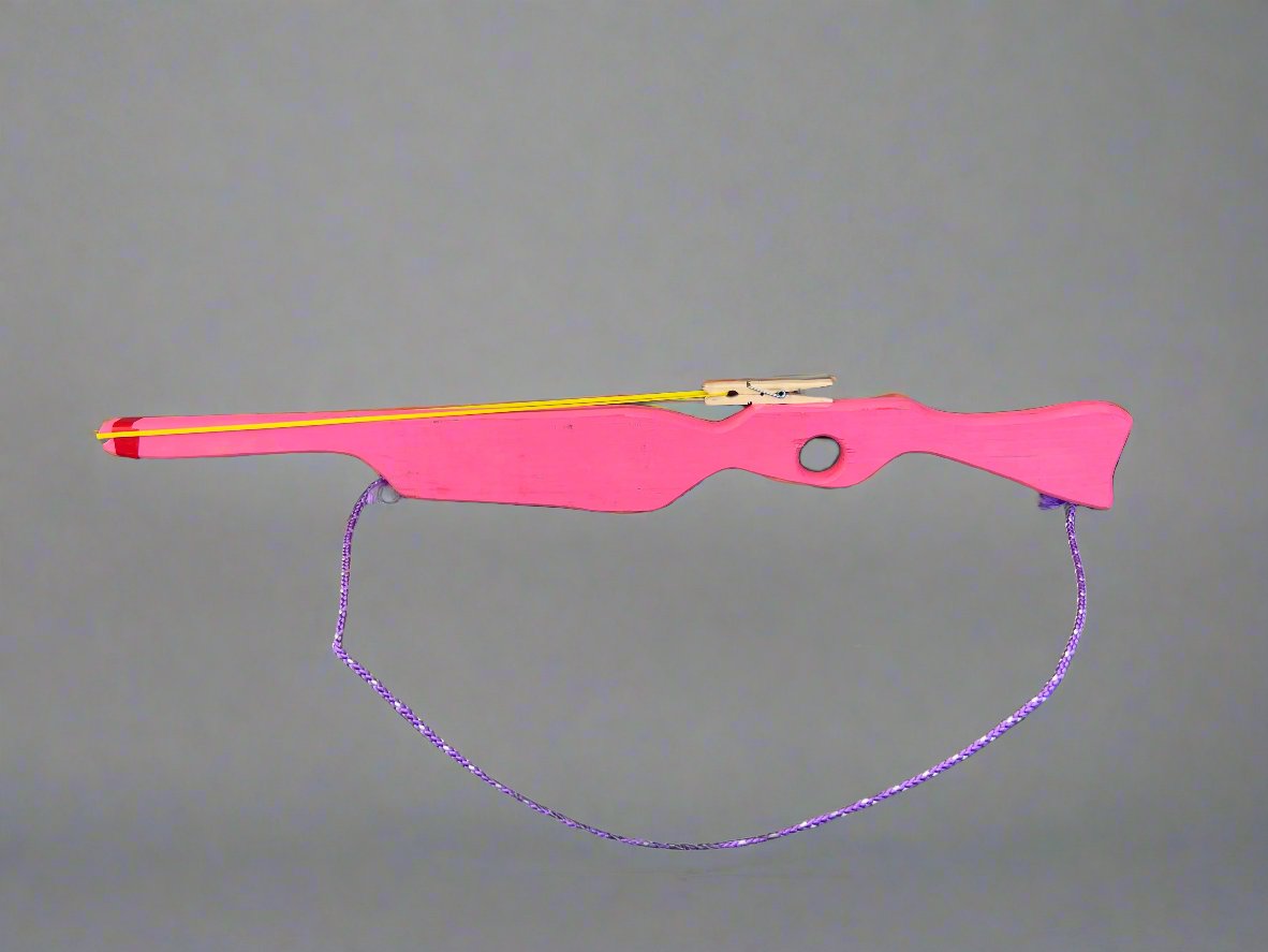 Pink kids wooden rubber band launcher toy with a purple string and wooden trigger mechanism