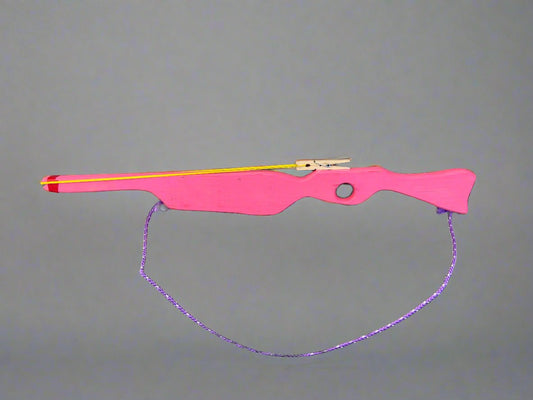 Pink kids wooden rubber band launcher toy with a purple string and wooden trigger mechanism