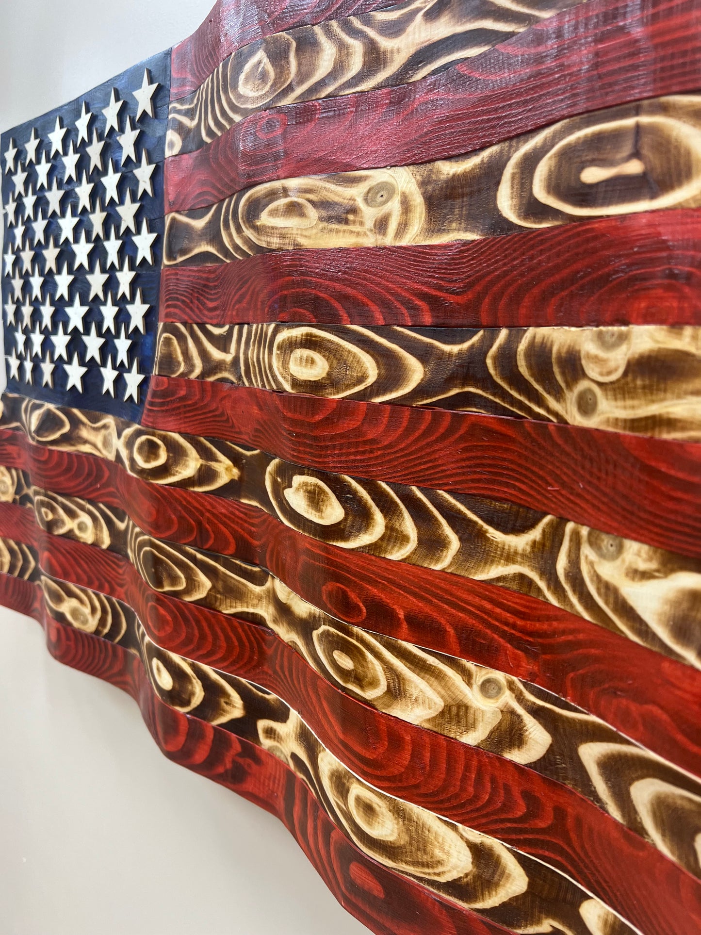 Close-up of rustic American flag wall art with distressed wood texture and carved stars