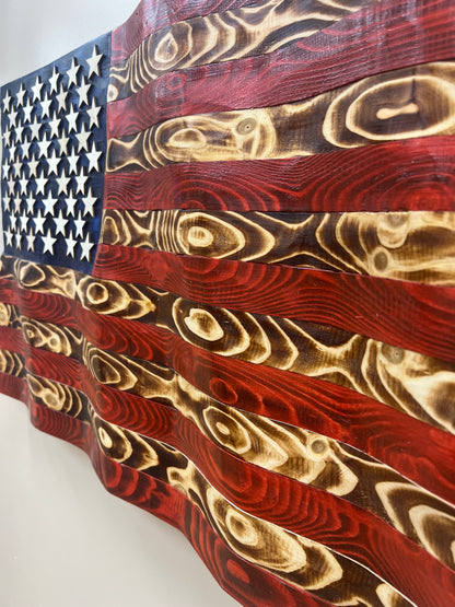 Close-up of rustic American flag wall art with distressed wood texture and carved stars
