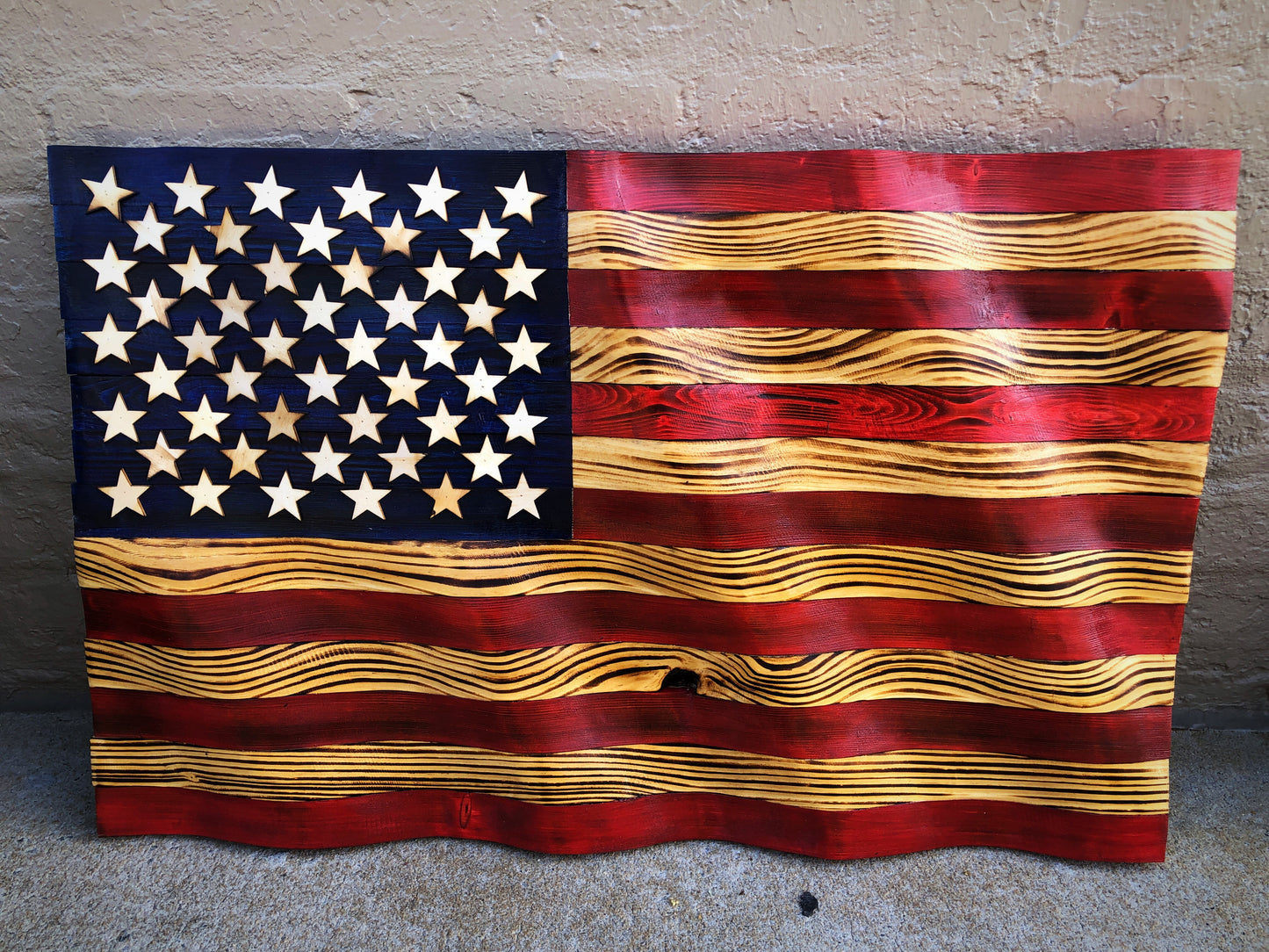 Rustic American flag wall art with carved wooden stars and stripes in red, white, and blue