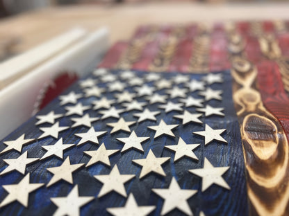 Close-up of rustic American flag wall art with wooden stars and distressed red and blue paint