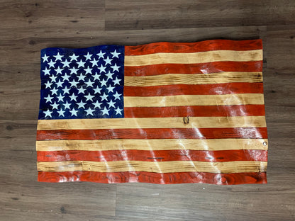 Rustic American flag wall art made of carved wood with distressed red, white, and blue paint