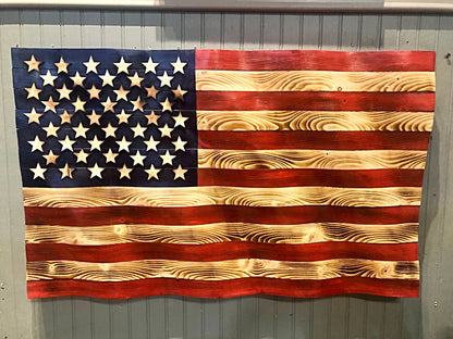 Rustic American flag wall art made of carved wood with natural grain and painted stars and stripes