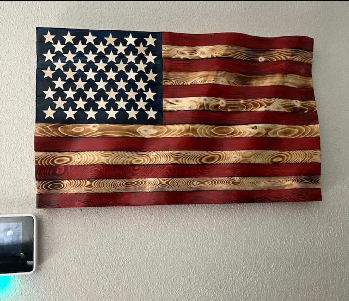 Rustic American flag wall art carved from wood with natural grain and distressed red and blue paint