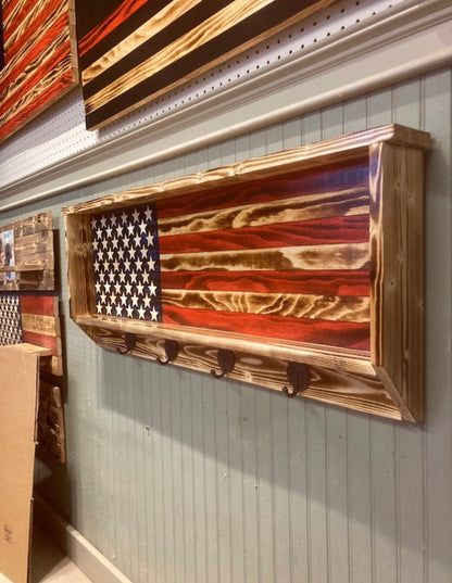 Rustic wood hat rack featuring a wooden American flag design with four metal hooks mounted on a wall