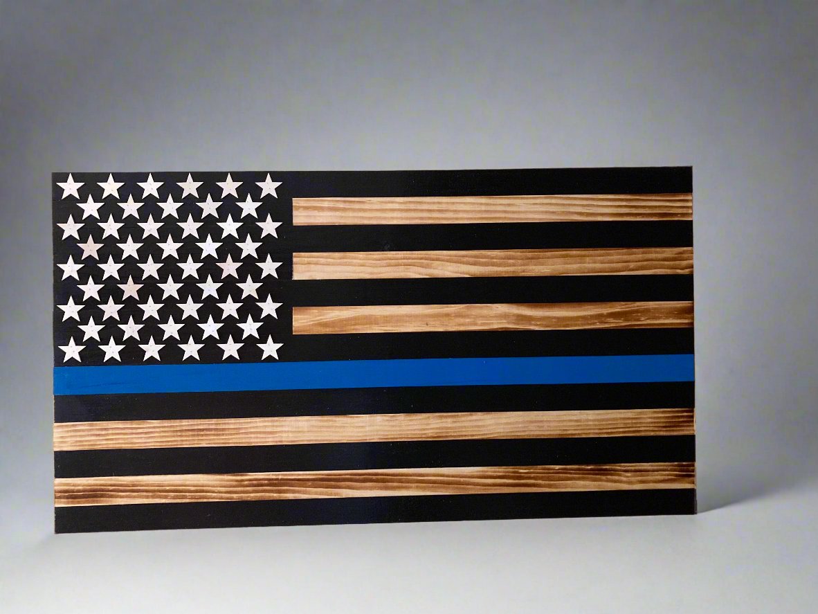 Thin blue line wooden flag with natural wood and black stripes and white stars on gray background