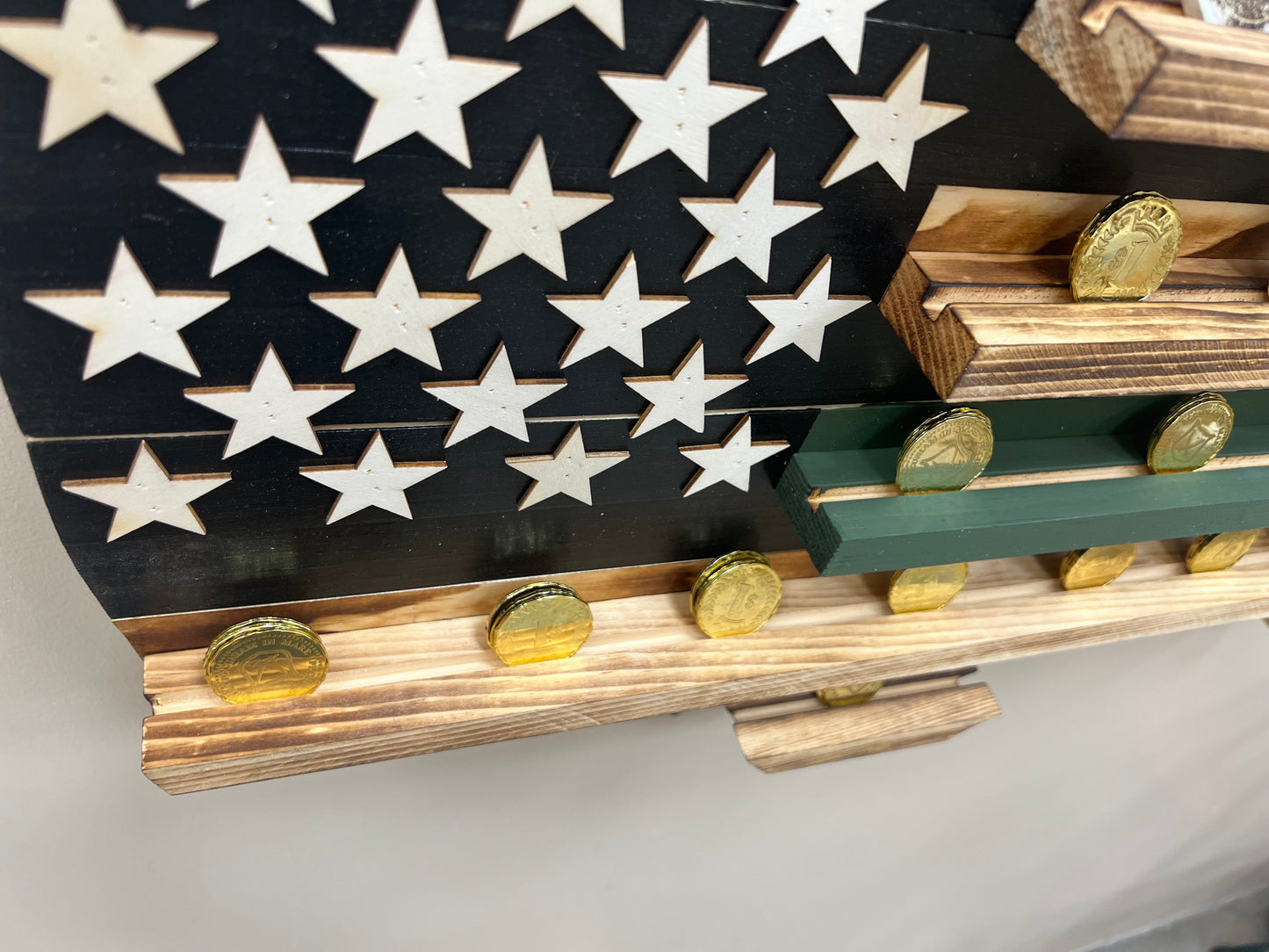 Thin green line wooden flag challenge coin holder displaying gold challenge coins on wooden shelves