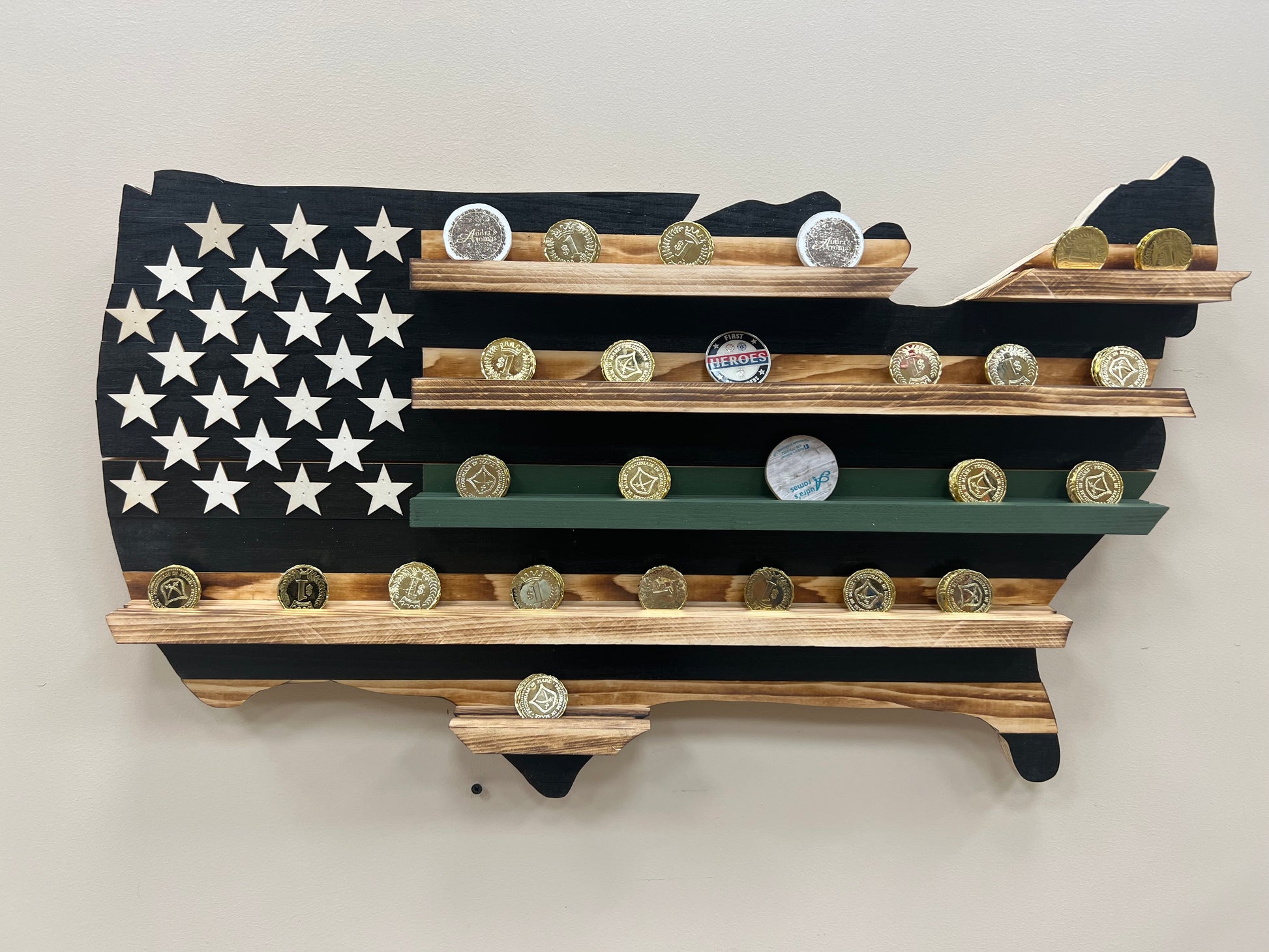 Thin green line wooden flag challenge coin holder shaped like the United States with shelves displaying challenge coins