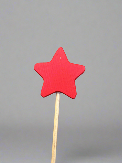 Colorful wooden magic wand toy with a red star top on a natural wood stick