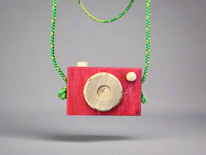 Handmade kids wooden camera in red with natural wood details and green strap hanging in front