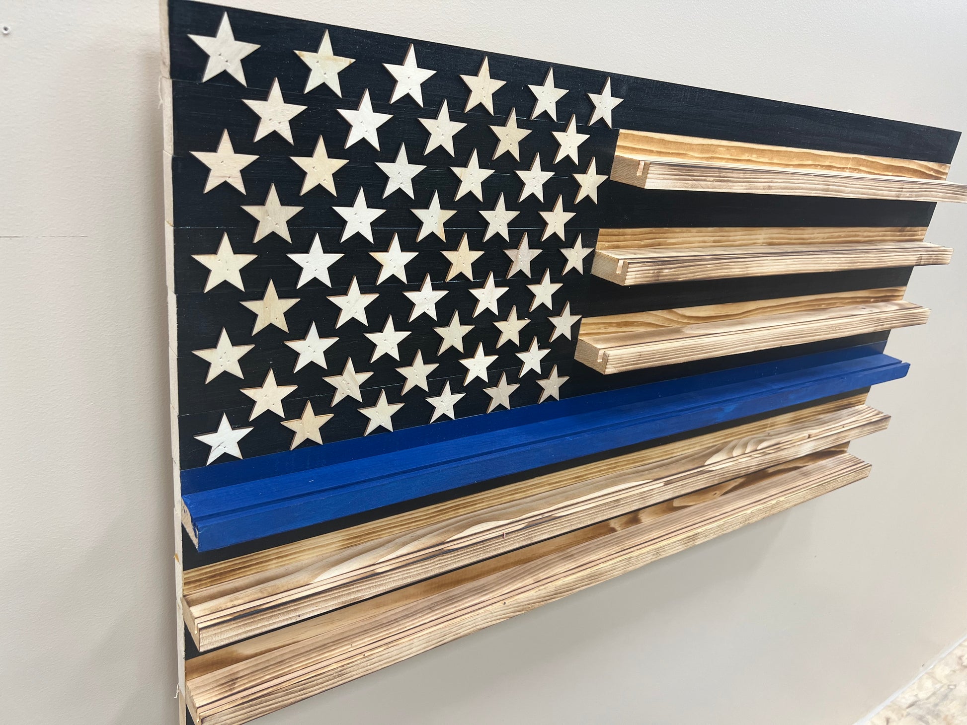 Wooden blue line flag coin holder display with star pattern and multiple wooden shelves for coins