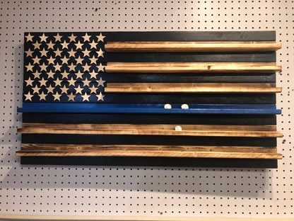 Wooden blue line flag coin holder display with natural wood stars and stripes on a pegboard background