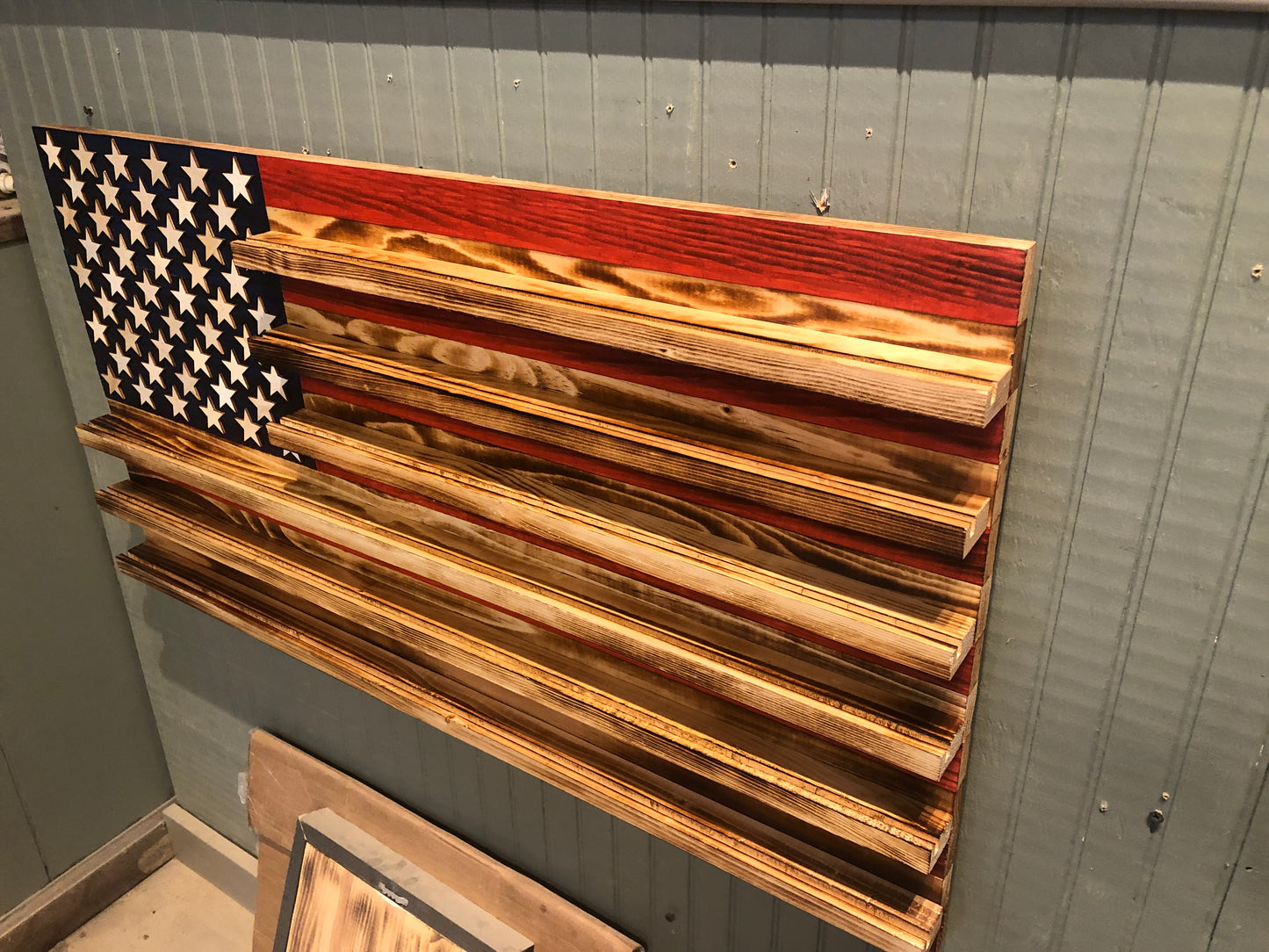 Wooden challenge coin holder flag wall art with American flag design and multiple coin display shelves