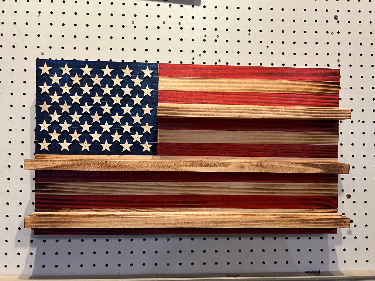 Wooden challenge coin holder flag wall art featuring an American flag design with shelves for displaying coins