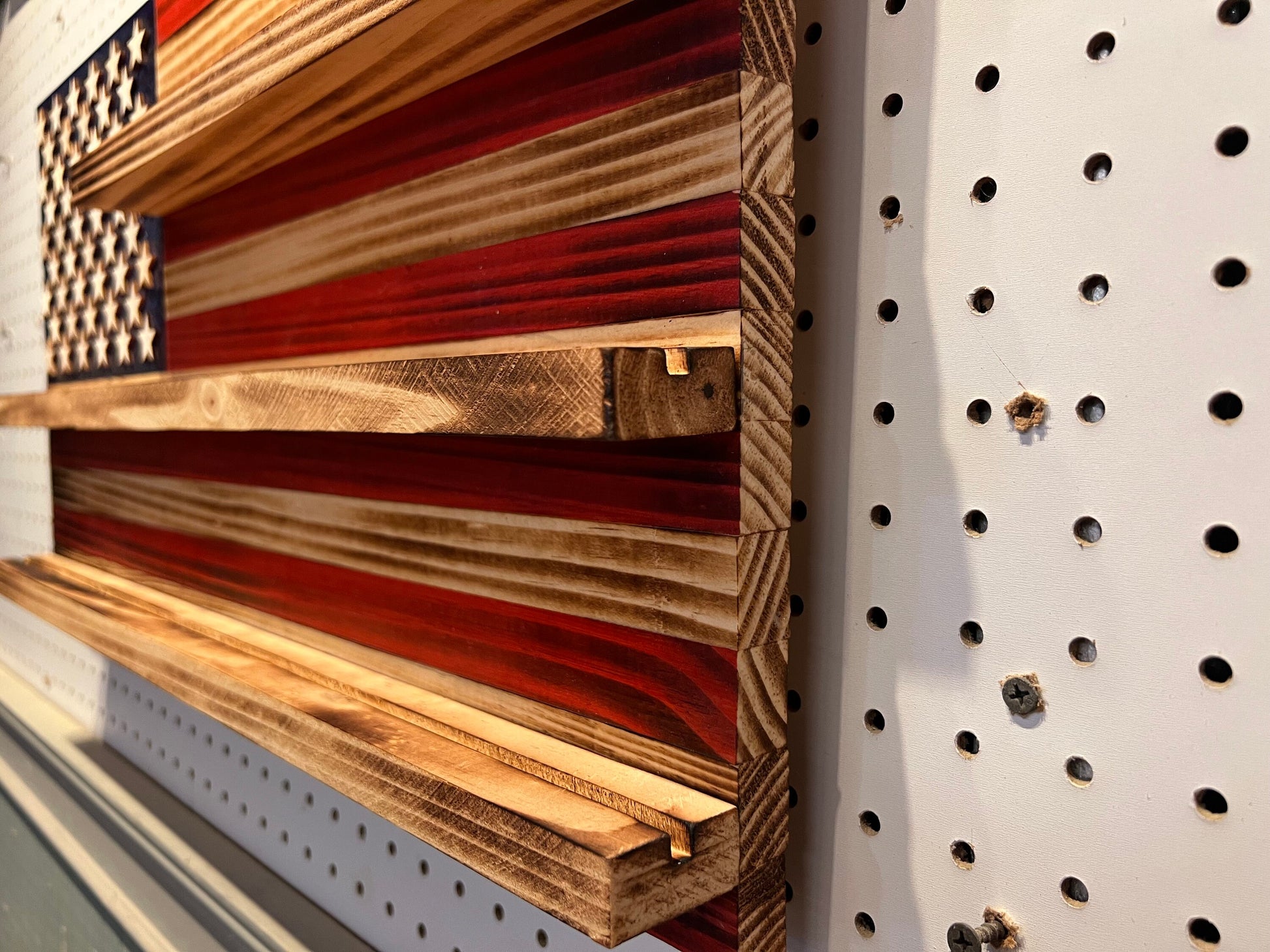 Wooden challenge coin holder flag wall art with deep shelves in red white and blue on pegboard