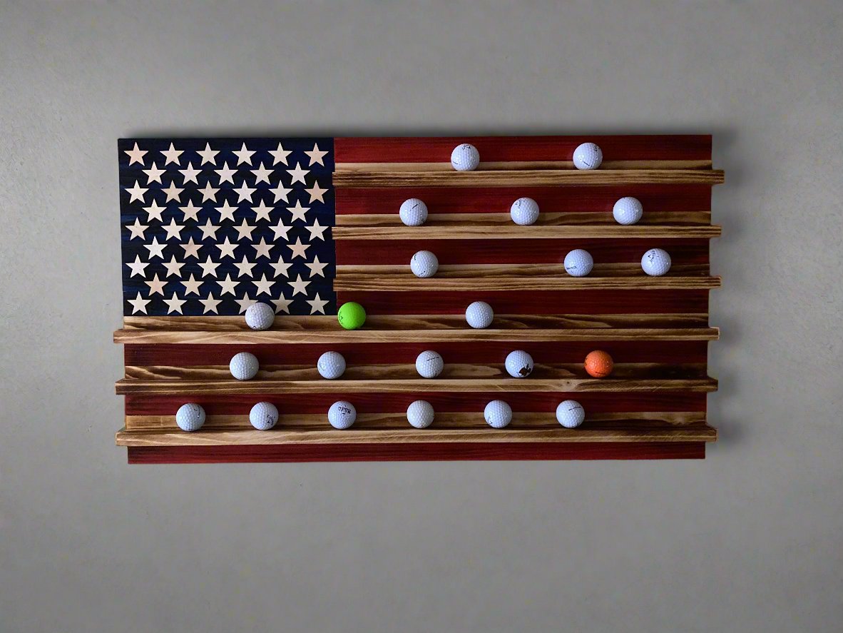 Wooden golf ball holder flag shaped like the American flag with white golf balls in slots