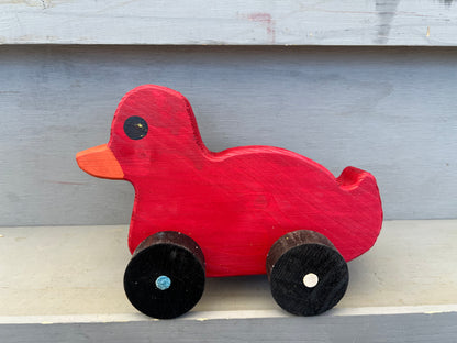 Red wooden pull duck toy with black wheels and orange beak perfect for children