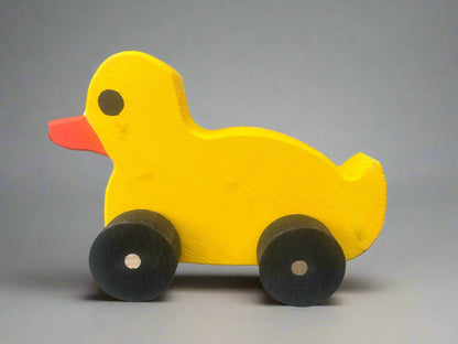Yellow wooden pull duck toy with black wheels and orange beak for children