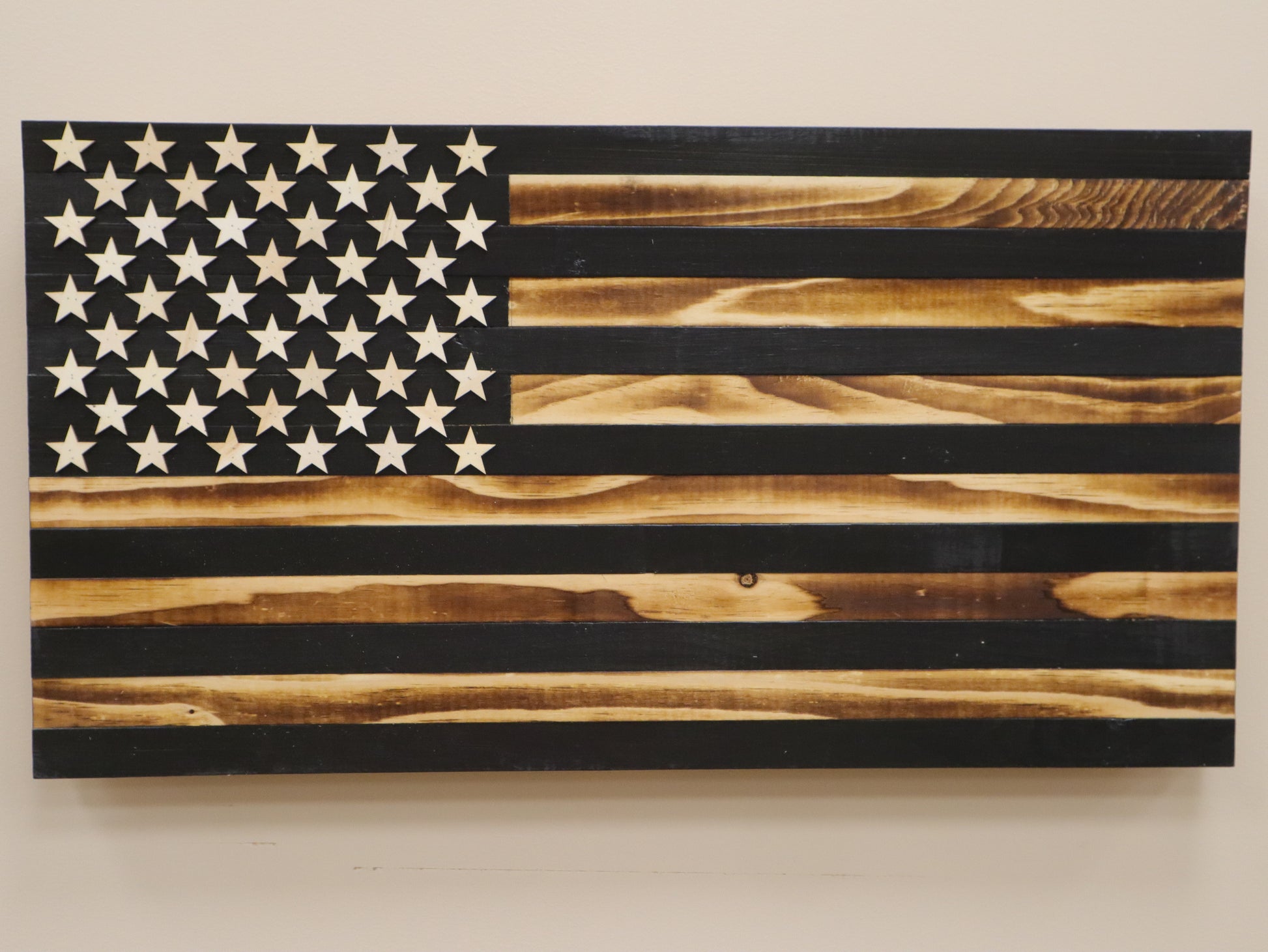 Subdued American flag wall art made of wood with rustic black and natural tones